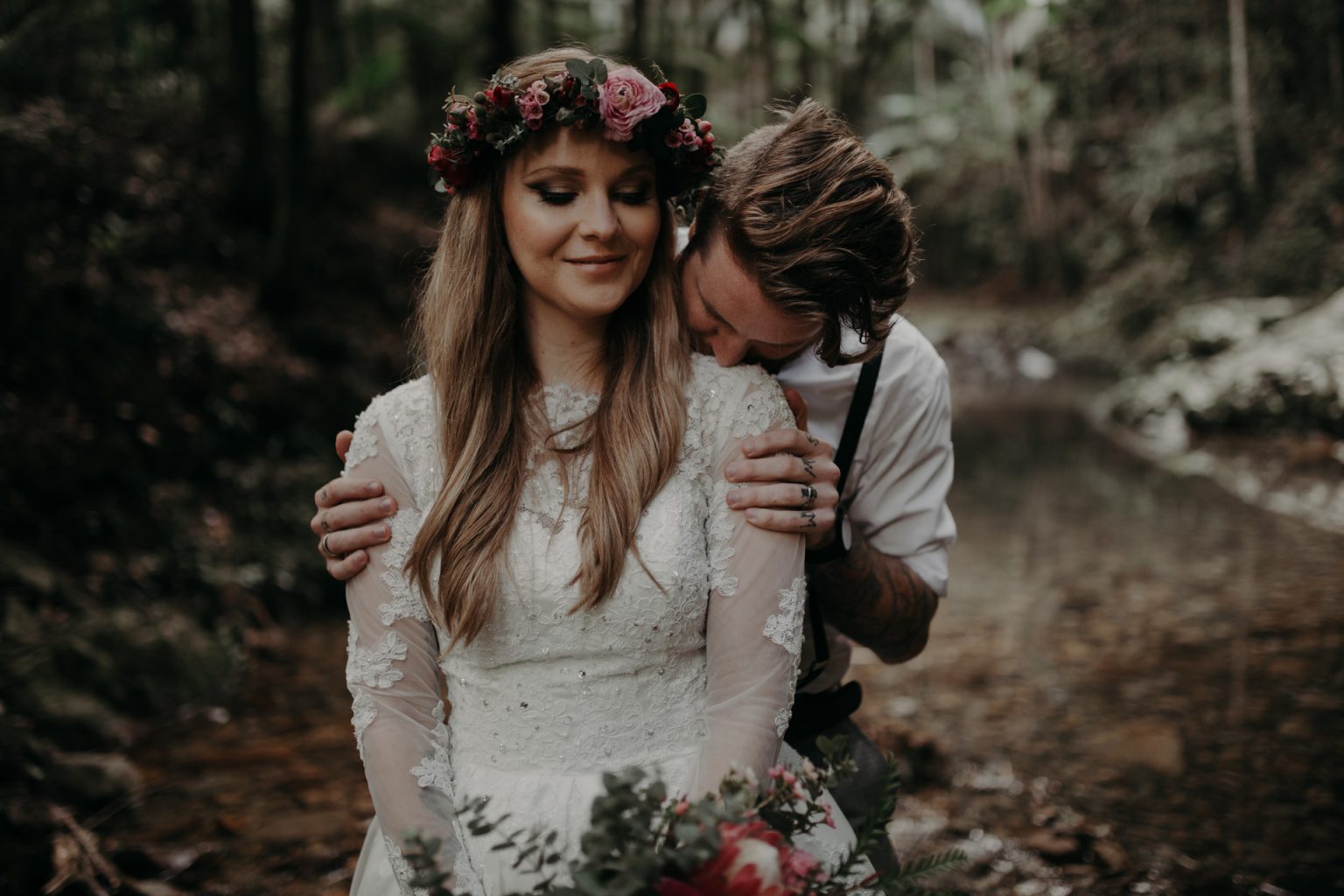 bride and groom hugging in forest