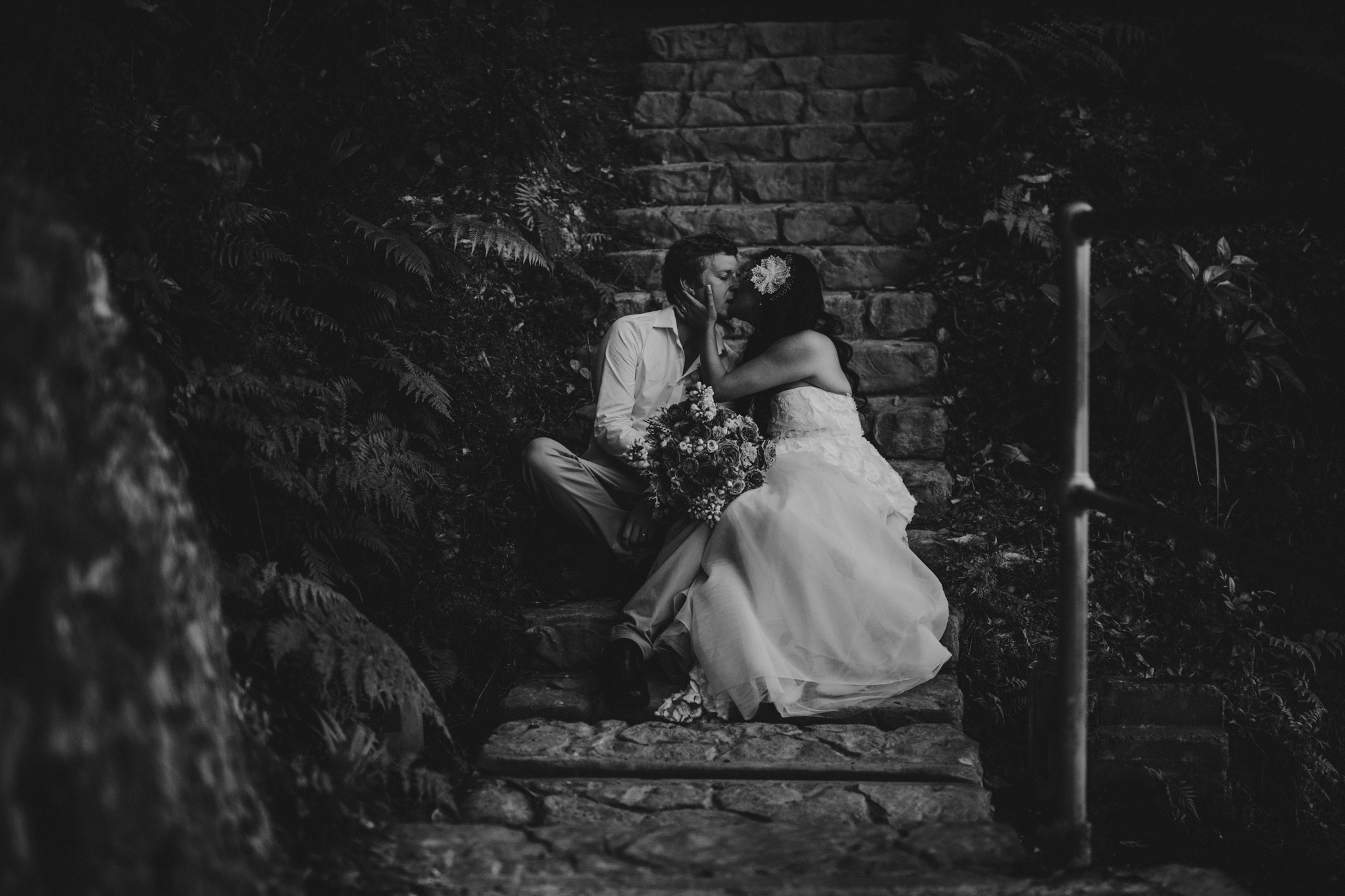 bride and groom kissing on stairs