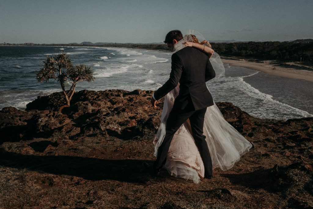 bride and groom dancing on clifftop