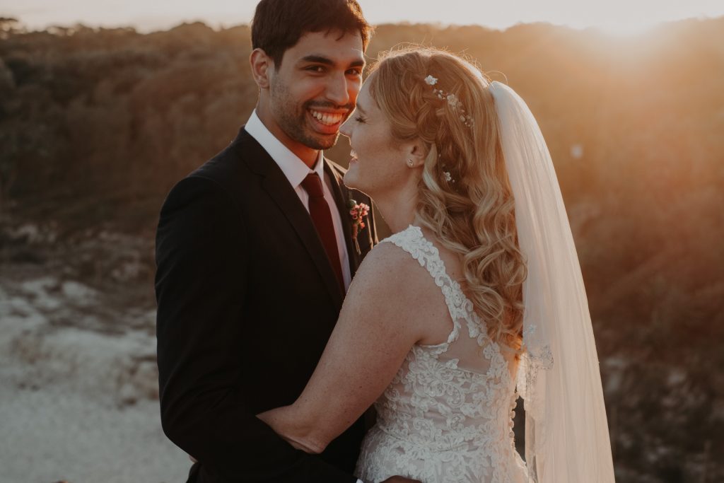 bride and groom in golden light on top of cliff elopement Fingal head