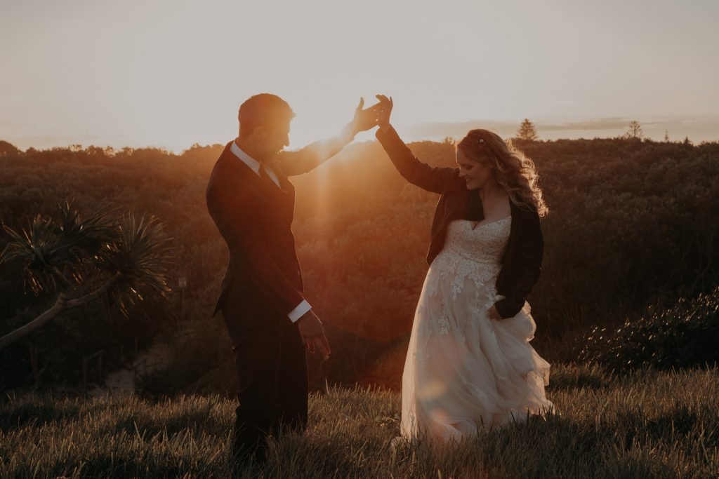 bride and groom dancing in golden light on top of cliff elopement 