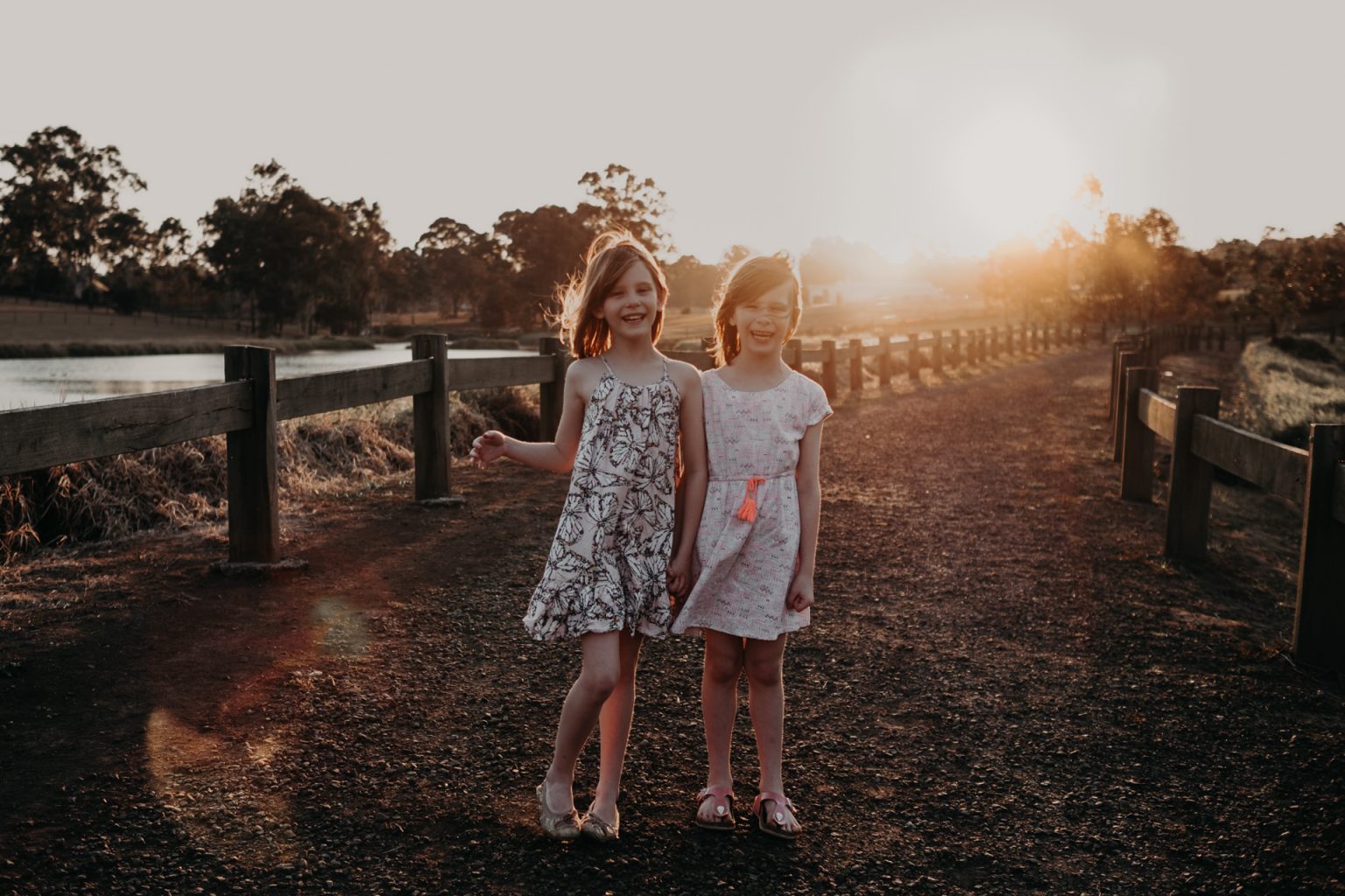 twin girls posing country lane golden light late afternoon sunset