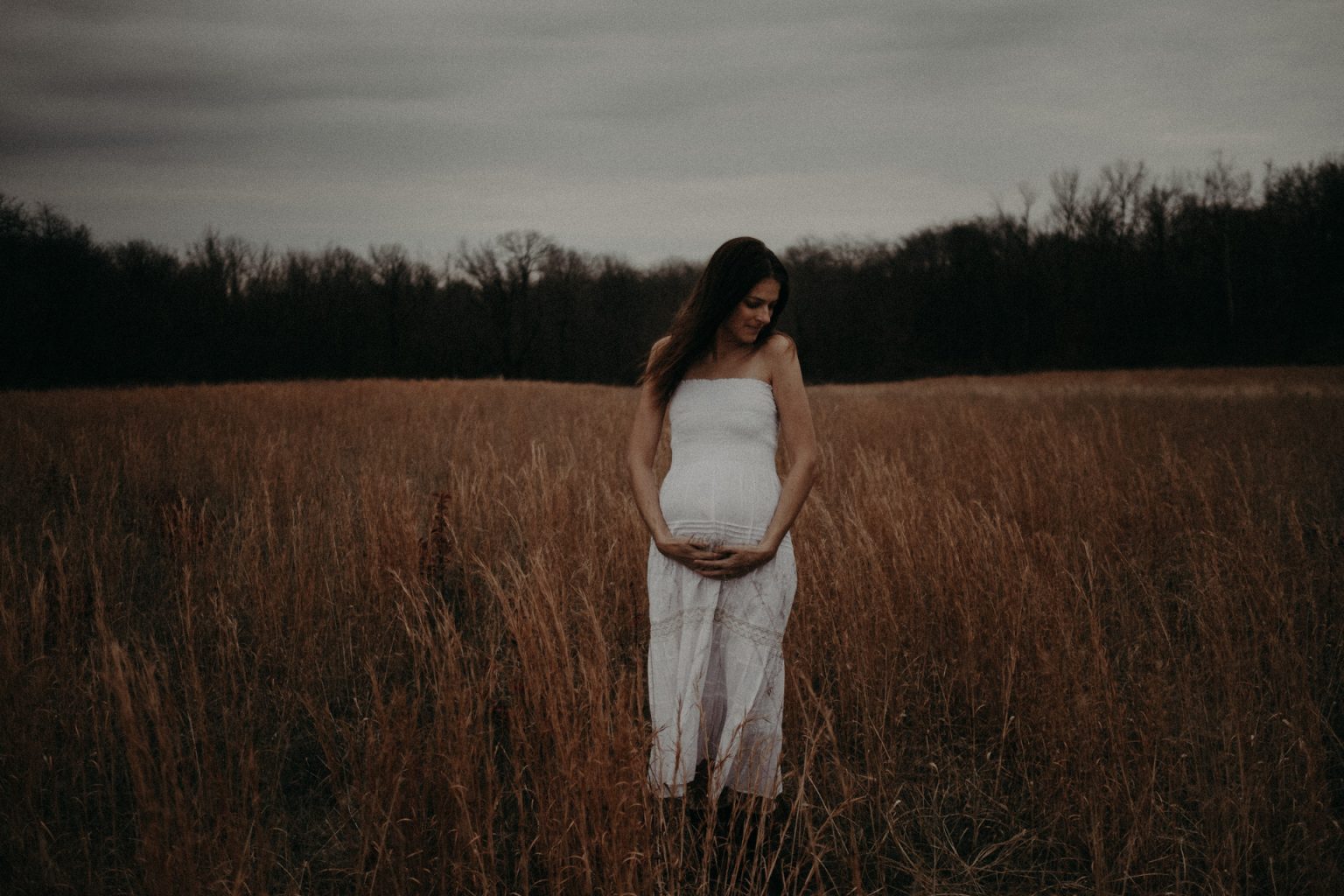 pregnant woman standing in field illinois