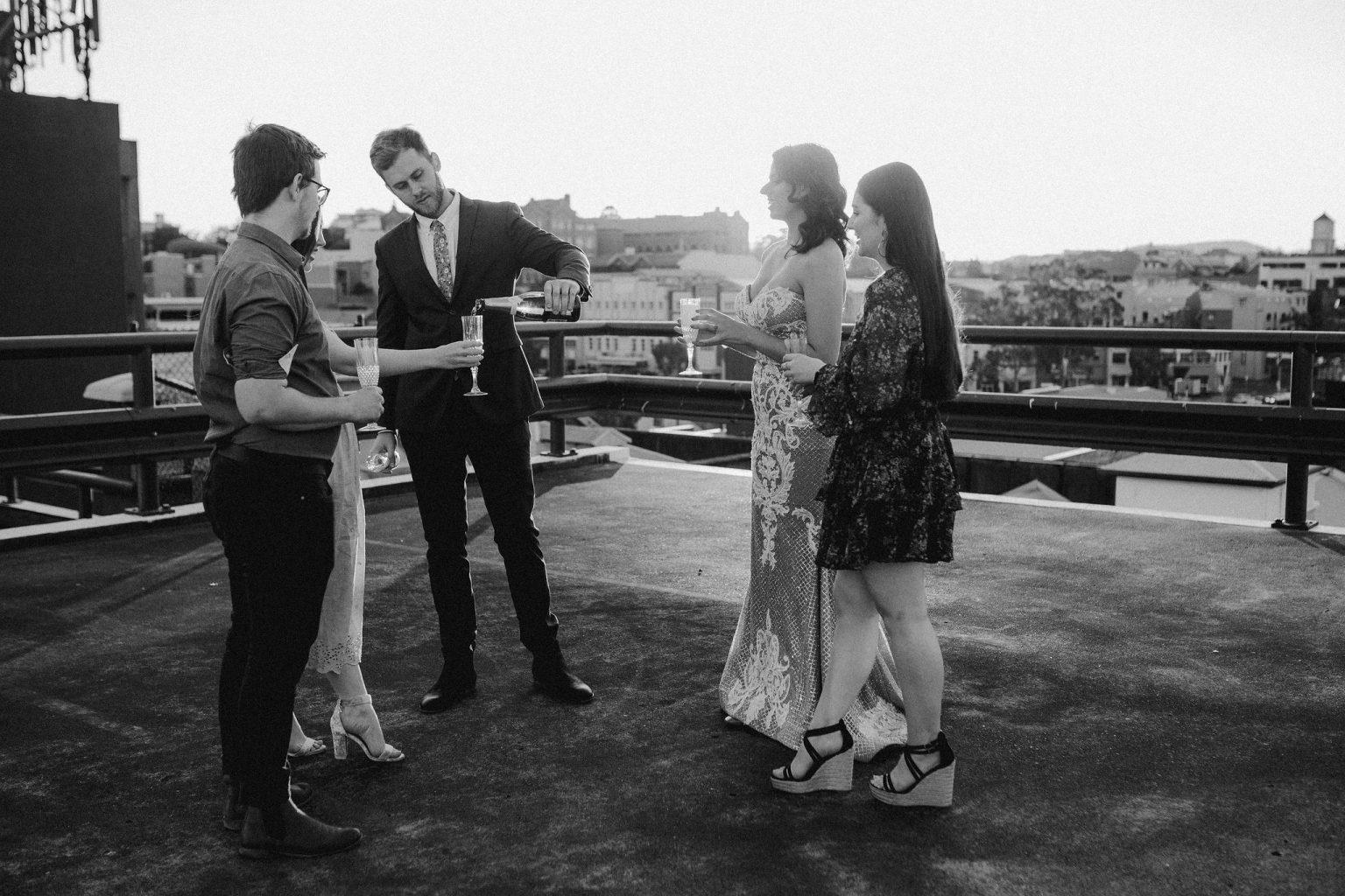 bride and groom drinking with bridal party on  rooftop for New York style elopement in Fortitude Valley Brisbane