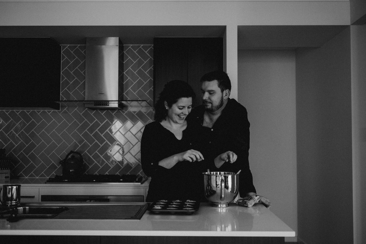 man and woman in kitchen making cupcakes