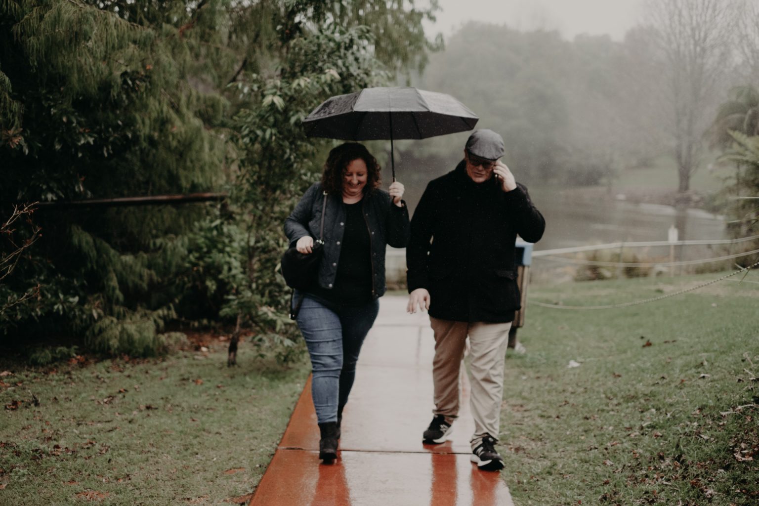 woman and man walking with umbrella