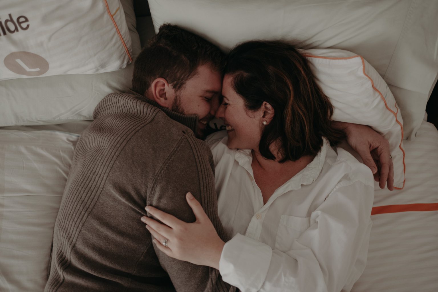 man and woman hugging in bed
