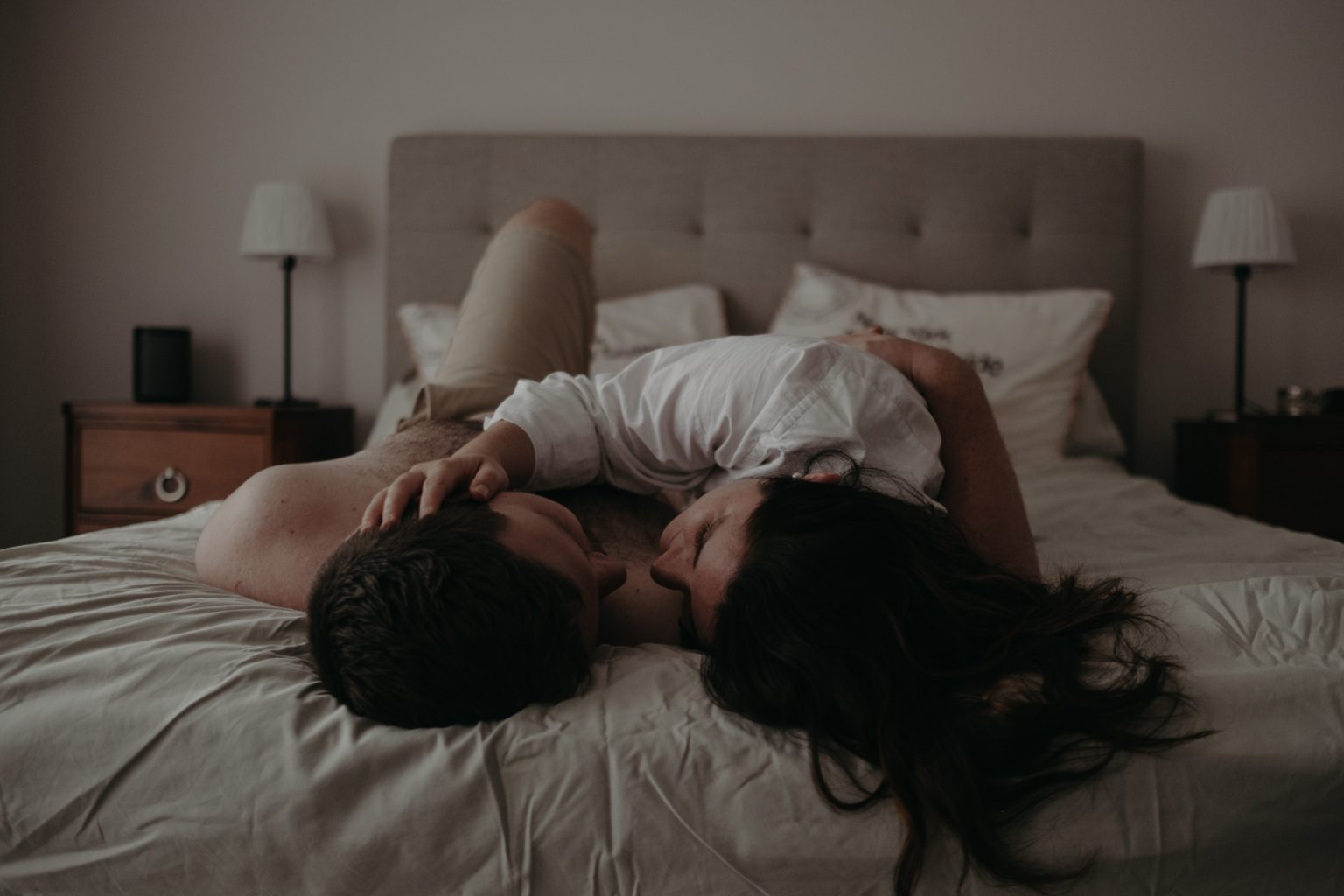 man and woman hugging in bed