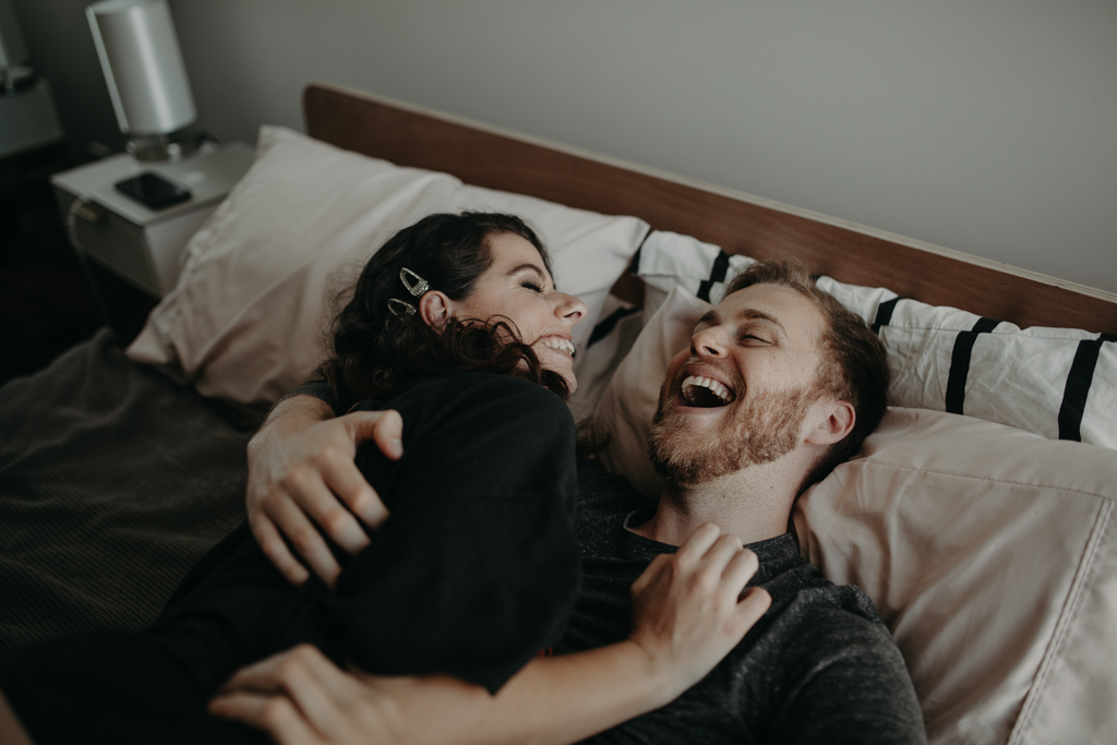 man and woman in bed laughing