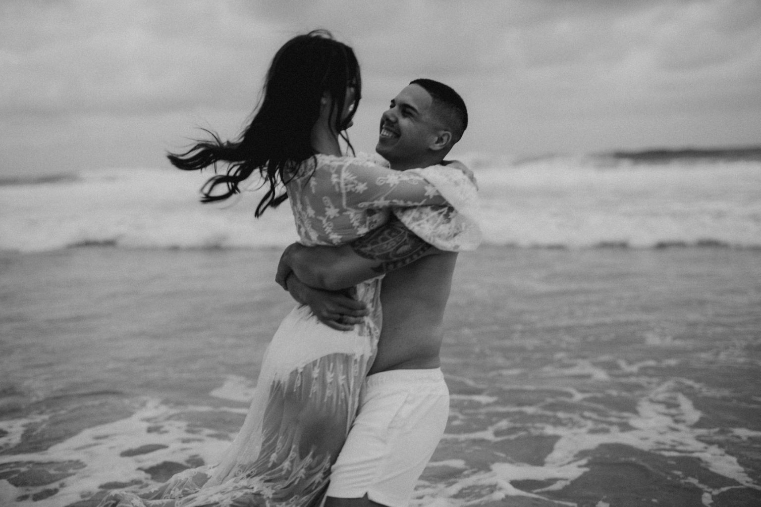tattooed man and woman wearing lace on beach