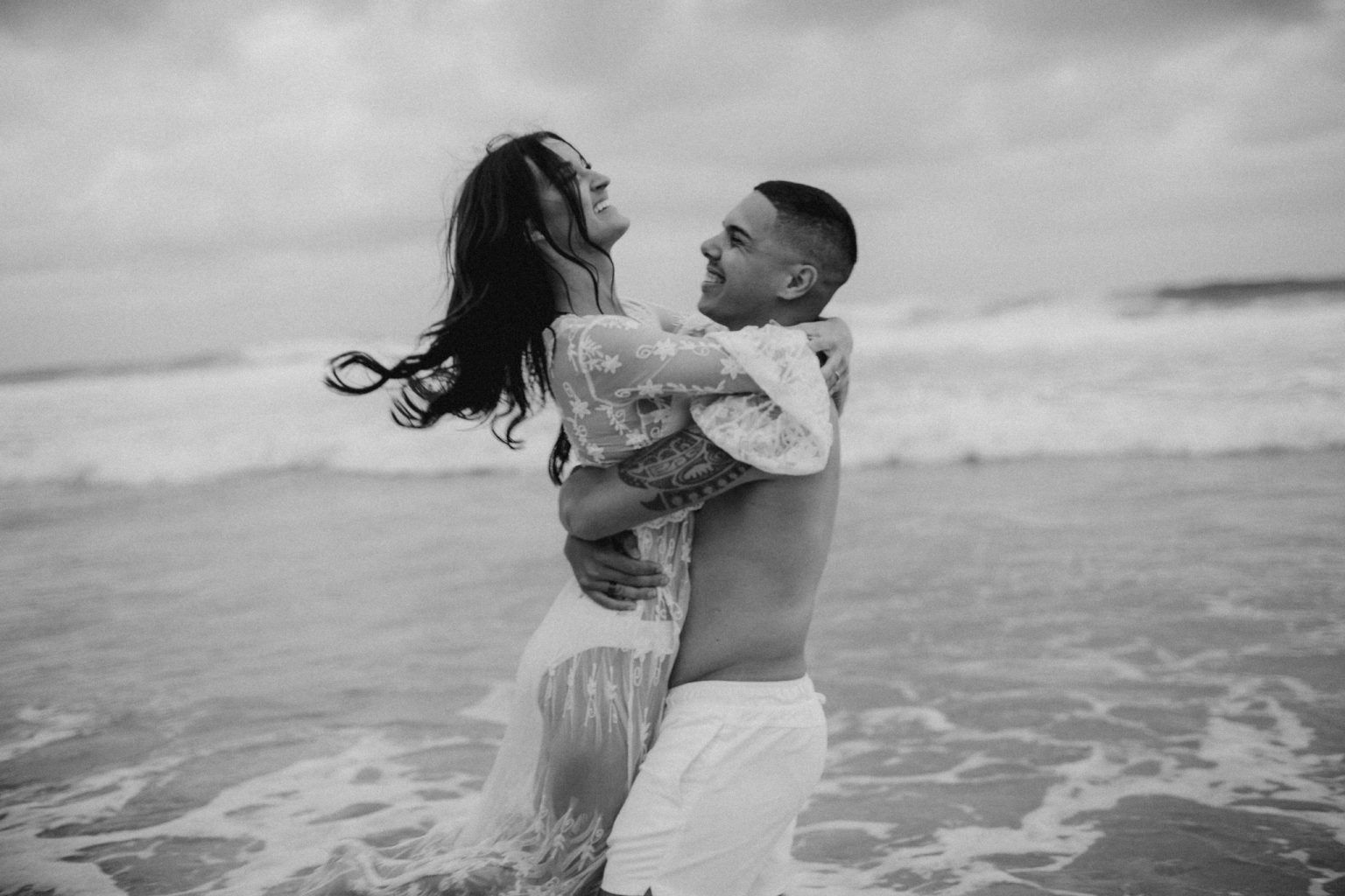 tattooed man and woman wearing lace on beach